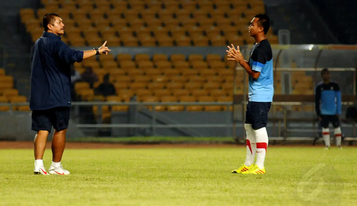 Pelatih timnas Indonesia U19, Indra Sjafrie, memberikan instruksi kepada salah satu pemainnya saat berlatih di Stadion GBK Jakarta, Sabtu (3/5/2014). (Liputan6.com/Helmi Fithriansyah)