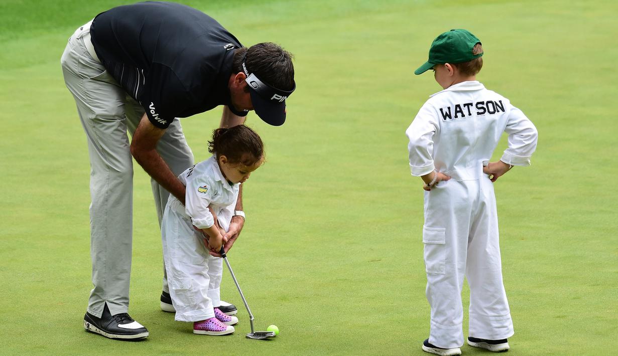 Pegolf Bubba Watson dari AS membantu putrinya Dakota putt saat mengikuti Masters Par 3 Tournament di Augusta National Golf Club, Georgia, (5/4). Anak-Anak ini menunjukkan keterampilannya bermain golf bersama orang tuanya. (Harry How/Getty Images/AFP)