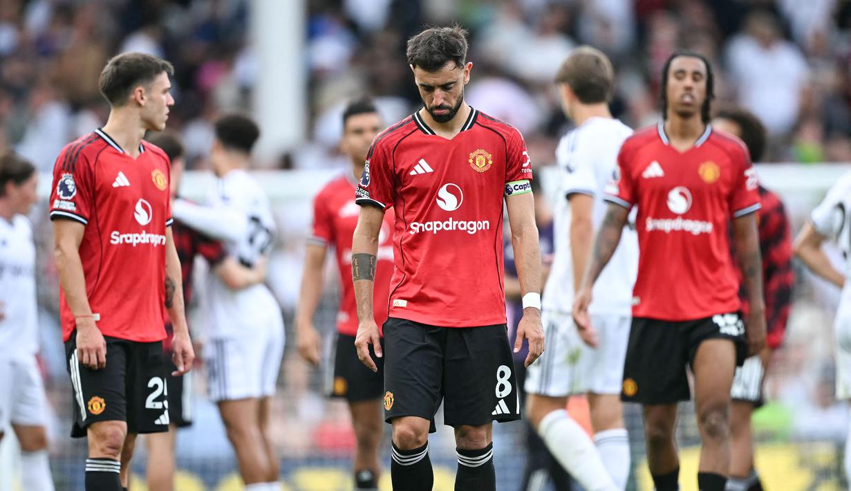 Pemain Manchester United, Bruno Fernandes, tertunduk lesu setelah MU ditahan imbang Fulham dalam laga pekan ke-2 Premier League 2025/2026 di Craven Cottage, Minggu (24/8/2025) malam WIB. (AFP/Justin Tallis)