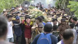 Laki-laki membawa seikat buah di tiang bahu selama perayaan Santa Cruz di Santa Maria Ostuma, 65 km timur San Salvador (31/5/2022). Ratusan orang Salvador membawa buah dengan yodes kayu berjalan melalui desa Santa Maria Ostuma di El Salvador tengah untuk berterima kasih kepada Salib Suci atas panen yang melimpah. (AFP/MARVIN RECINOS)