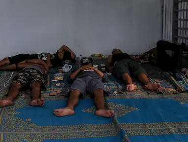 Sejumlah pemudik beristirahat sejenak di halaman rest area Tol Timur - Palimanan - Kanci,  Cirebon, Jawa Barat, Sabtu (1/7). Pada H+6 Lebaran pengguna jalan tol memanfaatkan rest area untuk makan, tidur sejenak. (Liputan6.com/Faizal Fanani)