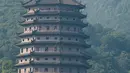 Warga menyaksikan gelombang pasang Sungai Qiantang dari Pagoda Liuhe di sepanjang sungai tersebut, Hangzhou, Provinsi Zhejiang, China, 4 Oktober 2020. Gelombang pasang Sungai Qiantang terjadi bertepatan dengan libur Hari Nasional dan Festival Pertengahan Musim Gugur tahun ini. (Xinhua/Jiang Han)