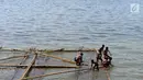 Anak-anak bermain air di batang kayu bekas dermaga sandar kapal tradisional di Kawasan Cilincing, Jakarta, Selasa (10/4). (Merdeka.com/Imam Buhori)