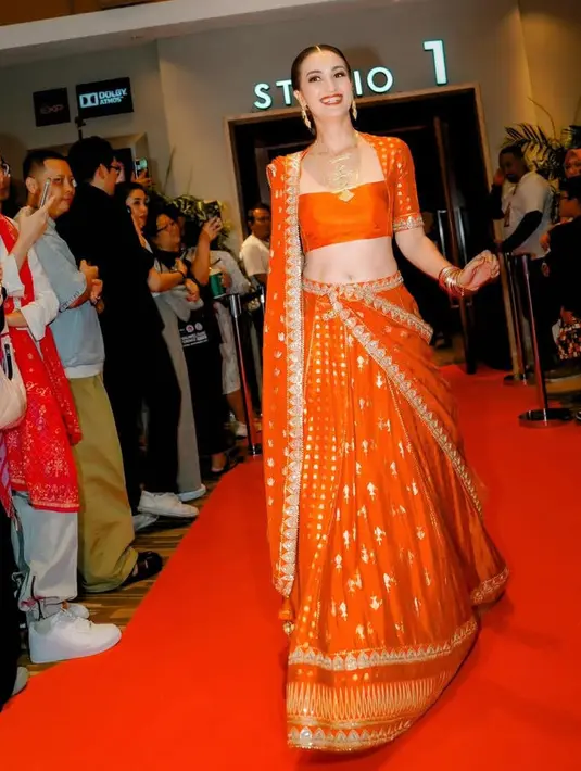 Sementara itu, Atiqah lebih memilih mengenakan lahenga warna merah menyala. Bagian atas model tube polos dengan lengan berocorak keemaaan serasi dengan rok dan selendangnya.[@atiqahhasiholan]