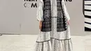 Citra Kirana tampil mengenakan kerudung dress panjang putih dengan motif hitam. Dress ruffle tersebut memiliki aksen warna  hitam dibagian atas. [@citraciki]