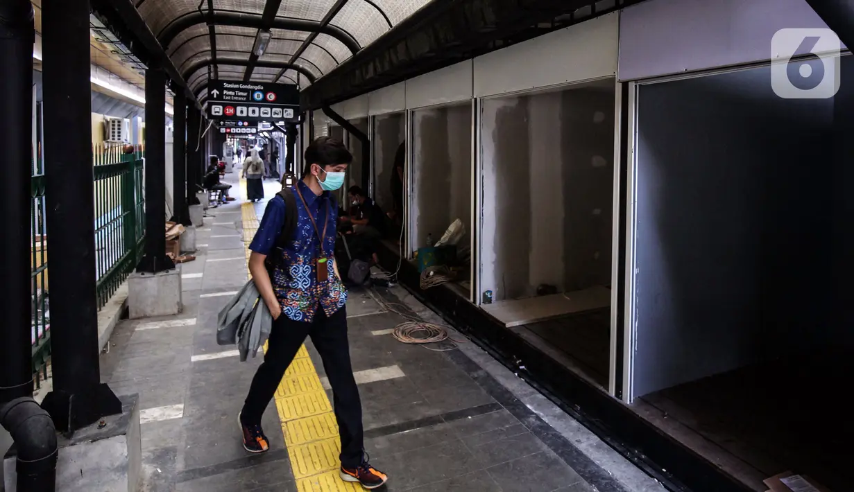 Warga melintas di depan ruko yang disiapkan untuk UMKM di stasiun Gondangdia, Jakarta, Sabtu (16/10/2021). Pembuatan ruko untuk para pedaganag di kawasan sekitar stasiun tersebut bertujuan agar terlihat lebih rapi dan modern. (Liputan6.com/Johan Tallo)