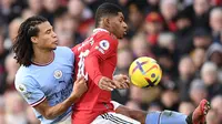 Bek Manchester City, Nathan Ake, melakukan pengawalan terhadap gelandang Manchester United, Marcus Rashford pada pertandingan pekan ke-20 Premier League 2022/2023 di Old Trafford, Sabtu (14/1/2022). (AFP/Oli Scarff)