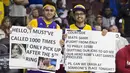 Dua orang Fans dari Italia memegang spanduk tanda dukungan untuk Bintang Los Angeles Lakers, Kobe Bryant  saat laga NBA di Wells Fargo Center, Philadelphia, Selasa (1/12/2015). 76ers menang atas Lakers 103-91. (AFP Photo/Mitchell Leff/Getty Images)