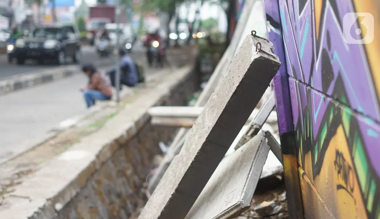 Kondisi tembok Jalan Juanda yang ambruk di kawasan Depok, Jawa Barat, Senin (2/12/2019). Kondisi tembok yang dipenuhi mural tersebut mulai rapuh dan sebagian sisinya telah ambruk serta miring sehingga membahayakan pejalan kaki. (Liputan6.com/Immanuel Antonius)