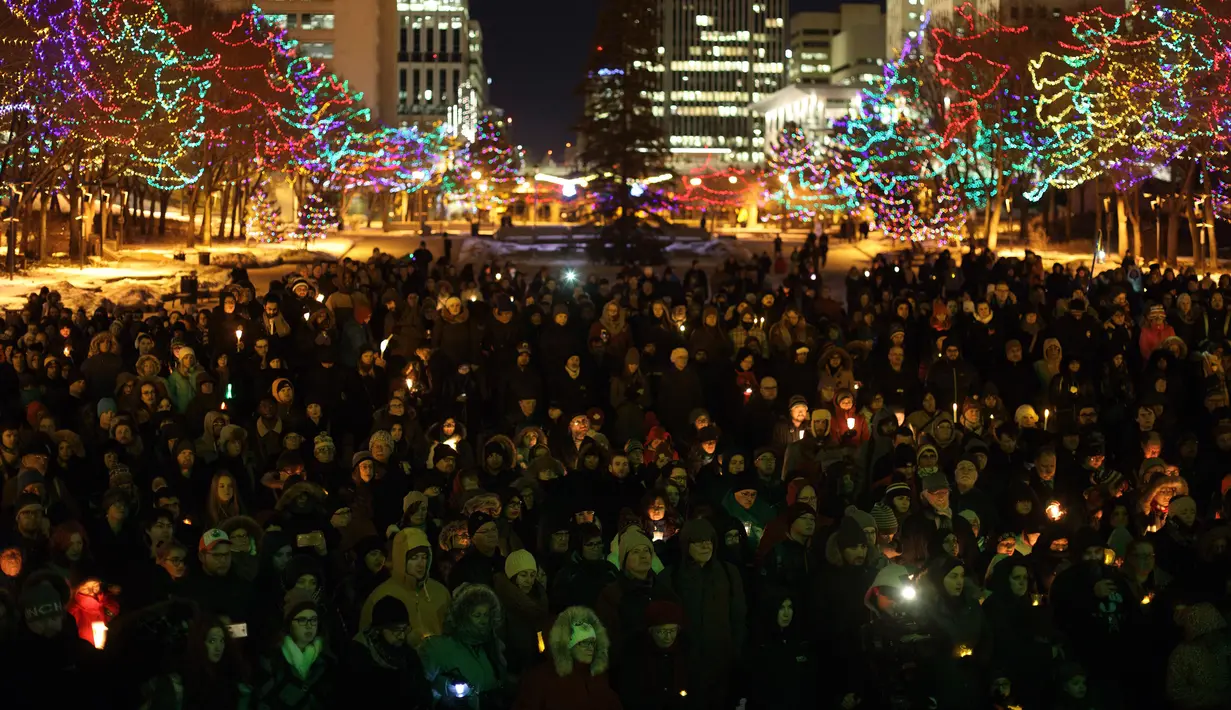 Ratusan orang berkumpul menyalakan lilin saat aksi dukungan pada komunitas muslim di Edmonton, Alberta, Senin (30/1). Dukungan itu setelah aksi penembakan di sebuah masjid di Quebec, Kanada yang menewaskan 6 orang (Jason Franson/The Canadian Press via AP)