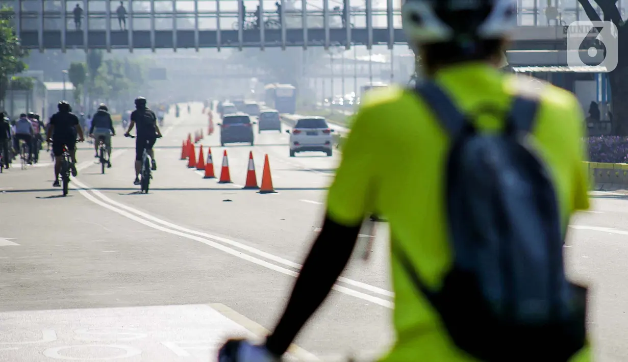 Warga berolahraga menggunakan sepeda di sepanjang Jalan Sudirman, Jakarta, Minggu (26/7/2020). Pemprov DKI Jakarta akan memperluas jalur sepeda sementara yang disiapkan sepanjang Jalan Medan Merdeka Barat hingga Jalan Sudirman dengan memakai 2-3 lajur di sebelah kiri. (Liputan6.com/Faizal Fanani)