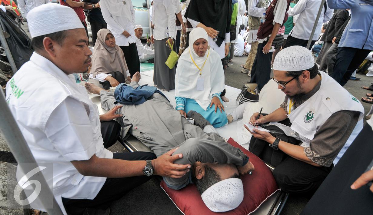 Sejumlah tim membantu demonstran yang kelelahan saat melakukan demo di depan Balai Kota, Jakarta, Jumat (4/11). Terlihat beberapa massa sedang beristirahat, dan ada juga yang sedang mendapat perawatan. (Liputan6.com/Yoppy Renato)