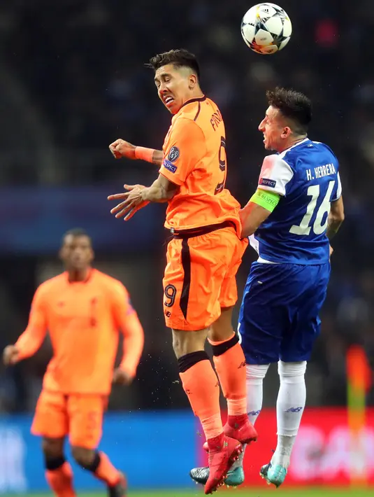 Pemain Liverpool, Roberto Firmino Liverpool melompat untuk merebut bola dari pemain FC Porto, Hector Herrera dalam leg pertama babak 16 besar Liga Champions di Stadion Do Dragao, Kamis (15/2). Liverpool menundukkan Porto dengan skor 5-0. (AP/Luis Vieira)