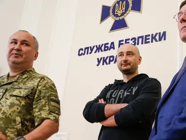 Wartawan terkemuka Rusia, Arkady Babchenko (tengah) menghadiri konferensi pers di Dinas Keamanan Ukraina, Rabu (30/5). Babchenko muncul kurang dari 24 jam setelah polisi melaporkan ia ditembak dan tewas di gedung apartemennya di Kiev. (AP/Efrem Lukatsky)