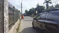 Salah seorang Pesapon membersihkan jalan di Jalan Raya Citayam, Kecamatan Cipayung, Kota Depok. (Liputan6.com/Dicky Agung Prihanto)
&nbsp;
