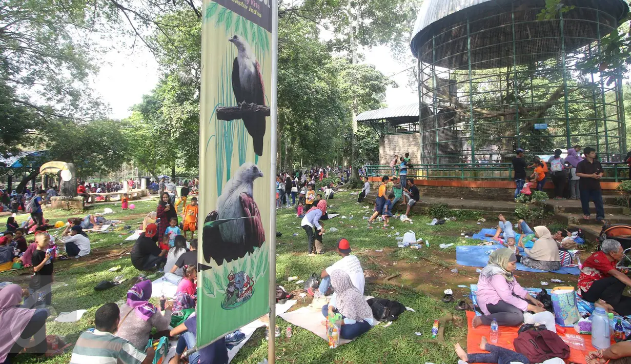 Sejumlah pengunjung menggelar tikar di depan kandang burung saat wisata ke Taman Margasatwa Ragunan, Jakarta, Kamis (7/7). Sampai pukul 15.00 WIB, jumlah pengunjung Ragunan pada hari kedua Lebaran ini sekitar 104.000 orang (Liputan6.com/Immanuel Antonius)