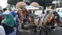 Delman hias membawa pengunjung di sekitar Museum Fatahillah, Jakarta, Rabu (20/6). Libur lebaran 2018, sejumlah PKL memenuhi kawasan Kota Tua Jakarta, akibatnya jalan di sekitar Museum Fatahillah semrawut. (Liputan6.com/Helmi Fithriansyah)