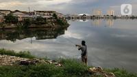 Warga memancing dekat pemukiman penduduk di kawasan Pluit, Jakarta, Kamis (10/12/2020). Wakil Gubernur DKI Jakarta Ahmad Riza Patria menyebutkan jumlah penduduk miskin di Jakarta meningkat 1,11 persen akibat terdampak pandemi Covid-19. (Liputan6.com/Immanuel Antonius)