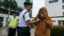 Petugas menghalau aktivis Orangutan di kawasan kantor HSBC, Jakarta, Kamis (9/2). Aksi tersebut ditujukan kepada HSBC agar menghentikan peranannya mendanai perusahaan minyak sawit yang merusak hutan dan gambut. (Liputan6.com/Gempur M Surya)