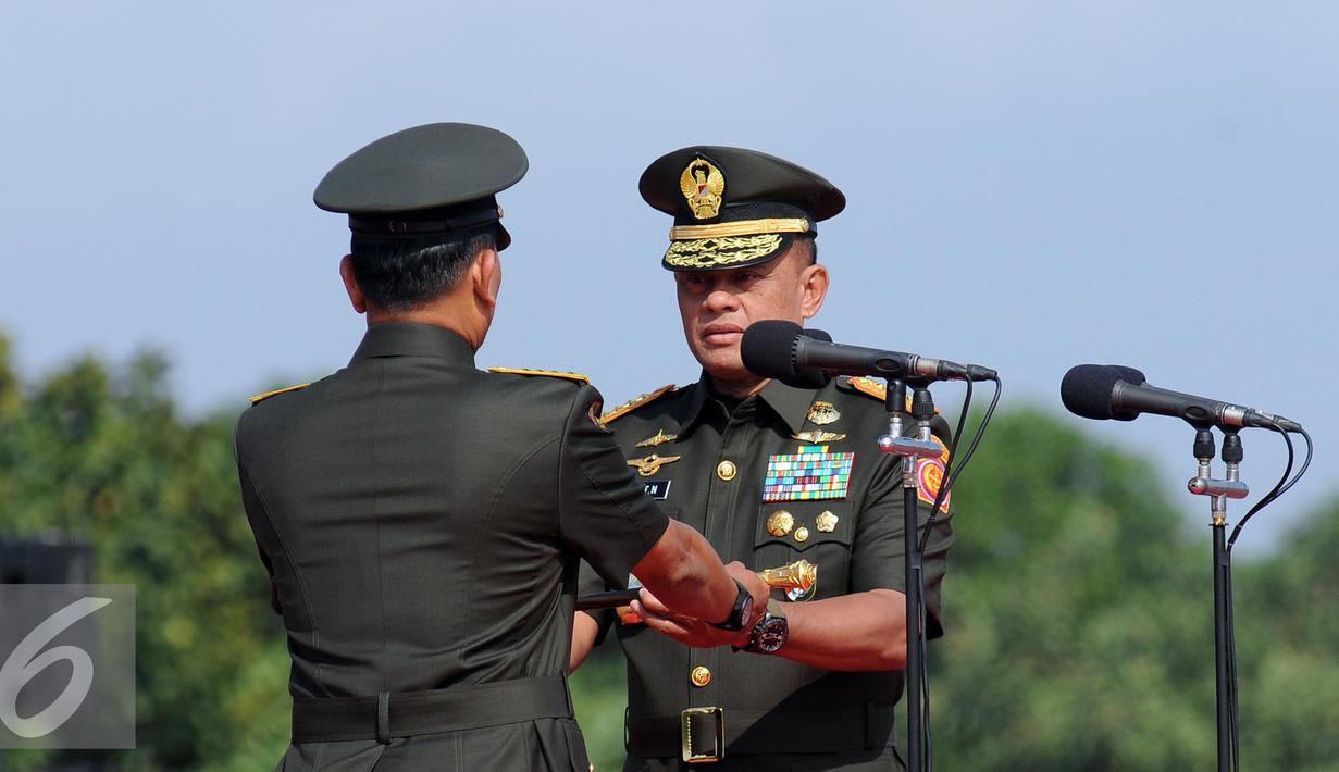 Jenderal TNI Gatot Nurmantyo (kanan) menerima tongkat komando dari Jenderal TNI Moeldoko saat Serah Terima Jabatan Panglima TNI di Mabes TNI Jakarta, Selasa (14/7/2015). Sertijab ini tindak lanjut Keppres No 49/TNI/2015. (Liputan6.com/Helmi Fithriansyah)