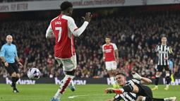 Pemain Arsenal, Bukayo Saka (kiri) berusaha mencetak gol namun digagalkan pemain Newcastle United, Sven Botman pada laga lanjutan Liga Inggris 2023/2024 di Emirates Stadium, London, Inggris, Minggu (25/02/2024) dini hari WIB. (AFP/Justin Tallis)