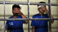 Dua pelaku penjambretan menutup wajahnya saat berada di dalam sel, Polsek Johar Baru, Jakarta, Senin (25/1/2016). Pelaku tertangkap dan dihakimi warga saat menjambret sebuah ponsel. (Liputan6.com/Yoppy Renato)