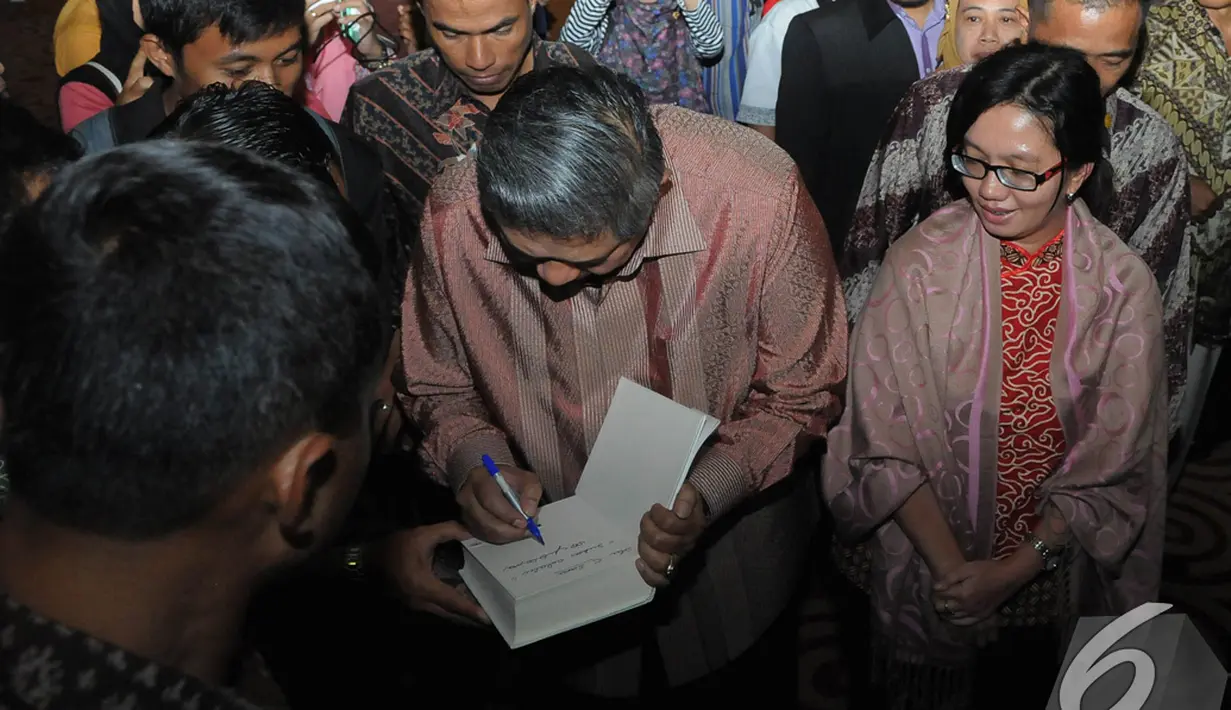 SBY membubuhkan tanda tangannya pada sebuah buku seorang mahasiswa yang ikut kuliah umum, Tangsel, Rabu (10/12/2014). (Liputan.com/Herman Zakharia)