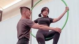 Tak sendirian, Fuji juga didampingi trainer saat latihan aerial hoop. Meski terlihat mudah, gerakan aerial hoop seperti yang dilakukan pemain film Bukan Cinderella ini mengerahkan banyak tenaga. (Liputan6.com/IG/@fuji_an)