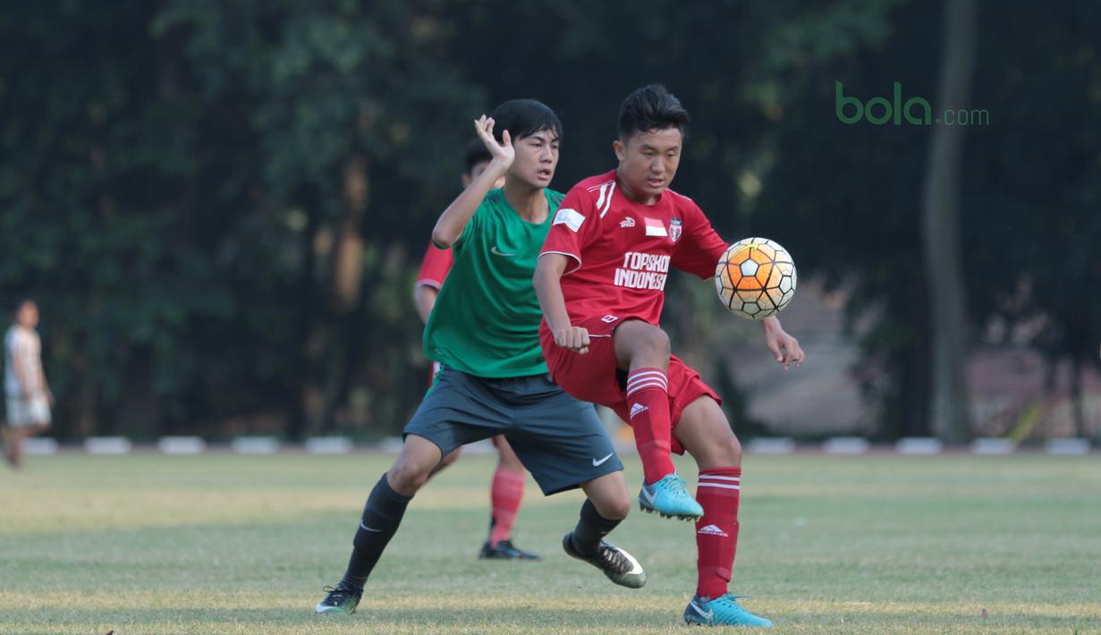 Aksi pemain Top Skor U-16, Jovinho mencoba melewati adangan pemain Timnas Indonesia U-16 pada laga uji coba di Lapangan Atang Sutresna, Cijantung, Kamis (10/5/2018). Tim Top Skor U-16 menang 2-0 atas Timnas Indonesia U-16. (Bola.com/Nick Hanoatubun)