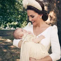 Pangeran Louis digendong oleh ibunya, Kate Middleton, di taman Clarence House usai pembaptisannya. (Twitter @KensingtonRoyal)