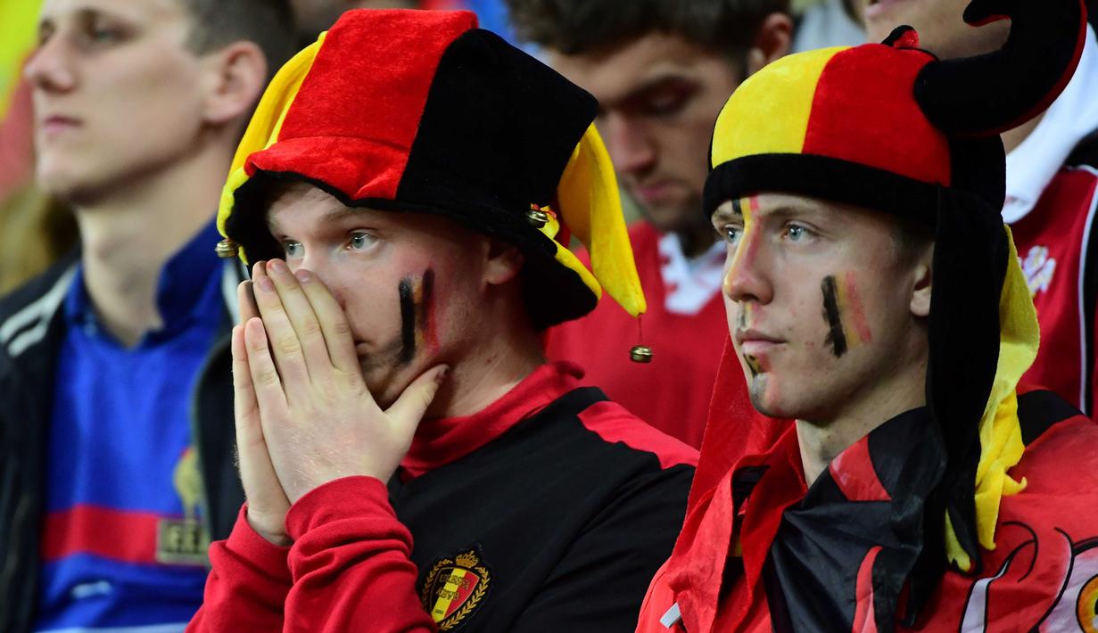 Suporter Belgia terlihat sedih usai timnya kalah dari Wales 1-3 pada laga perempat final Piala Eropa 2016 di Stade Pierre-Mauroy, Lille, Prancis, Sabtu (2/7/2016) dini hari WIB. (AFP/Emmanuel Dunand)
