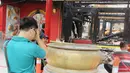 Seorang warga sembahyang di depan sisa-sisa kebakaran Wihara Dharma Bakti, Petak Sembilan, Jakarta, Kamis (19/3/2015). Wihara yang lebih dikenal dengan Petak Sembilan ini terbakar pada 2 Maret 2015 lalu. (Liputan6.com/Helmi Afandi)