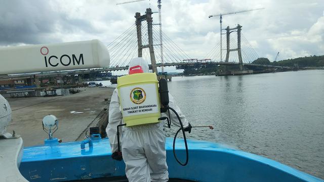 Penyemprotan disinfektan pada kapal penumpang pelabuhan Kendari oleh personil Polda Sultra untuk antisipasi Corona Covid-19.(Liputan6.com/Ahmad Akbar Fua)