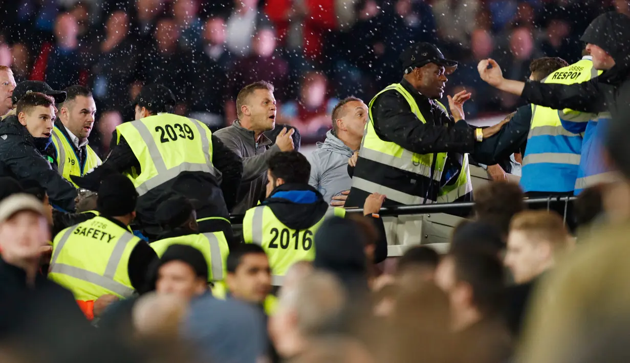 Para petugas mengamankan keributan antar pendukung West Ham United dengan Pendukung Chelsea saat pertandingan Piala Liga Inggris (EFL Cup) di Stadion London, Inggris (26/10).  (Reuters/John Sibley)