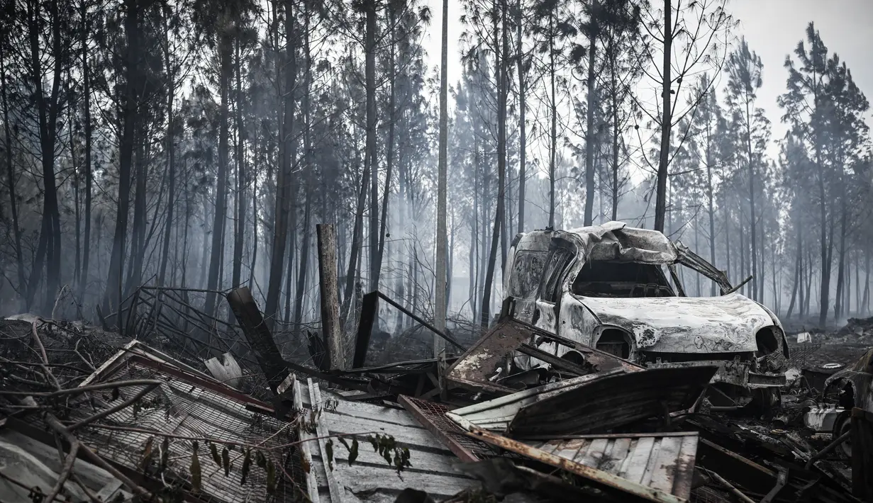 Sebuah mobil yang terbakar oleh kebakaran hutan di Saumos, pinggiran barat Bordeaux, barat daya Prancis (13/9/2022). Kebakaran yang berlangsung sejak 12 September 2022 telah menyebar sekitar 1800 hektar vegetasi dan hutan di Saumos dan memaksa evakuasi kota dalam konteks suhu tinggi di Gironde. (AFP/Philippe Lopez)