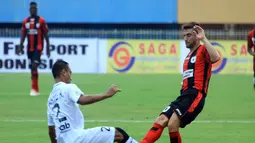 Pemain serbabisa Persipura Robertino Pugliara berduel dengan bek Bali United Wahyu Kristanto. (Liga Indonesia)