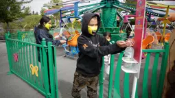 Seorang pengunjung membersihkan tangannya usai menaiki wahana di Playland Amusement Park, di Vancouver, British Columbia, Kanada, pada 10 Juli 2020. Playland Amusement Park dibuka kembali untuk umum pada Jumat (10/7), dengan langkah-langkah protokol kesehatan. (Xihua/Liang Sen)