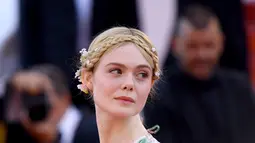 Elle Fanning berpose saat tiba menghadiri screening film "Les Miserables" dalam acara Festival Film Cannes ke-72 di Prancis (15/5/2019). Elle Fanning tampil dengan tatanan rambut kepang milkmaid oleh hairstylist Jenda Alcorn. (AP Photo/Arthur Mola)