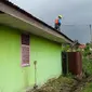 Petugas PLN memperbaiki aliran listrik di atap rumah warga yang sebelumnya menewaskan seorang nenek. (Liputan6.com/M Syukur)