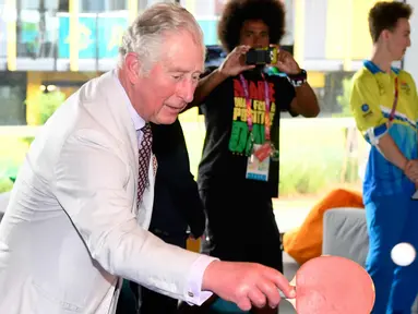 Pangeran Charles memukul bola saat bermain tenis meja selama kunjungannya ke desa atlet Goldwe Common Games 2018 di Gold Coast (5/4). Dalam kunjungannya Pangeran Charles ditemani sang istri Camilla Parker. (AFP Photo/Pool/William West)