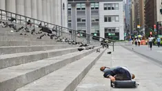 Seseorang tidur di dekat Penn Station di Madison Square Gardens, New York City pada Kamis (17/9/2020). Sejak pandemi virus corona, para tunawisma kini lebih terlihat seiring banyaknya penutupan banyak tempat penampungan karena alasan kesehatan. (Angela Weiss / AFP)