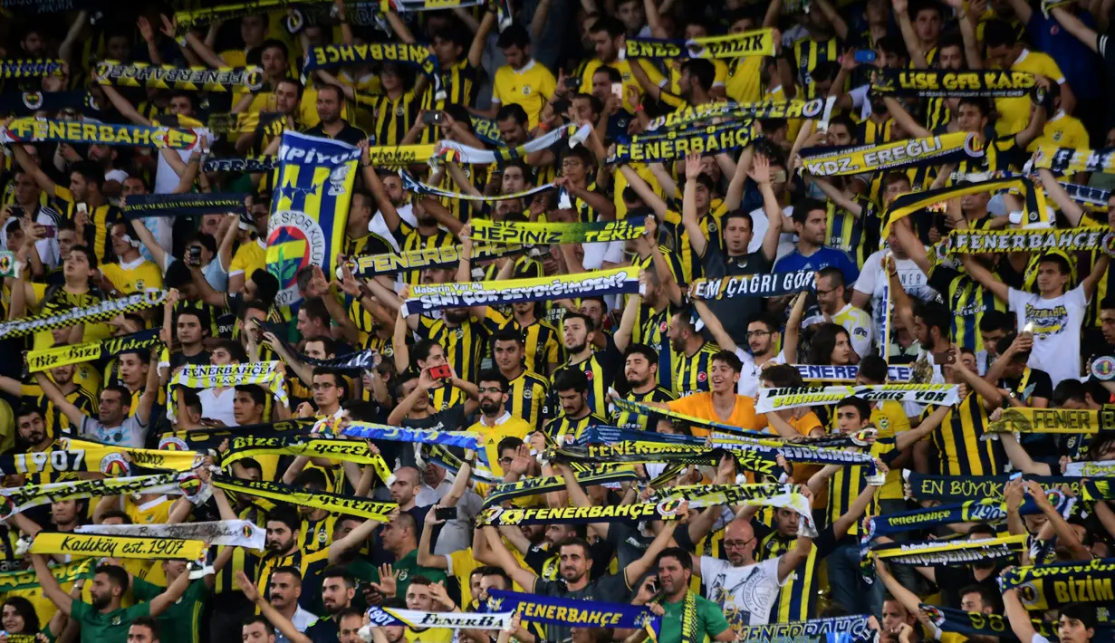 Para suporter saat mendukung tim kesayangannya bertanding pada putaran ketiga kualifikasi UEFA Europa League antara Fenerbahce dan Sturm Graz di Stadion Ulker Fenerbahce di Istanbul (3/8). Fenerbahce bermain imbang 1-1. (AFP Photo/Ozan Kose)