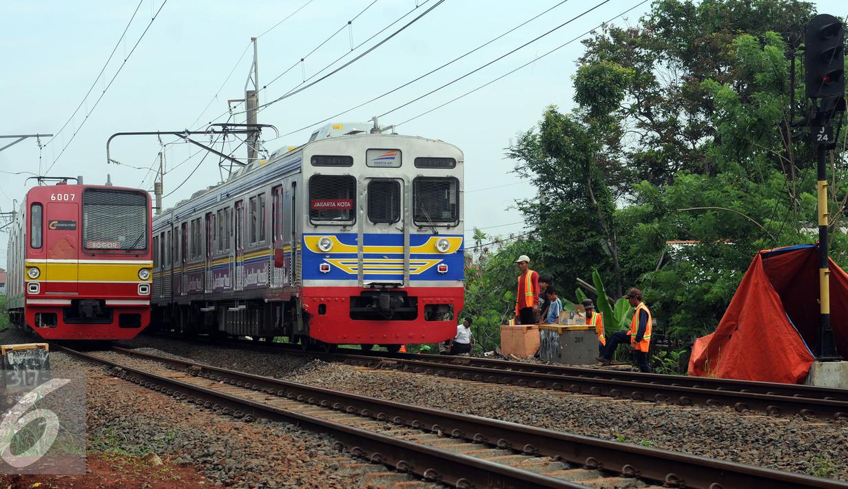 Kereta Commuter Line melintasi lokasi perbaikan kondisi tanah yang longsor di sekitar Kampung Pabuaran, Citayam, Bogor, Rabu (25/11/2015). Sebelumnya, Selasa (24/11) tanah di sekitar rel KM 38 dan 39 mengalami longsor. (Liputan6.com/Helmi Fithriansyah) 