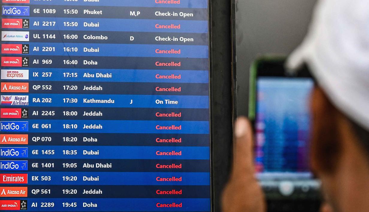 Sementara bandara-bandara seperti Bandara Internasional Dubai dan Bandara Internasional Zayed di Abu Dhabi, tetap beroperasi untuk layanan darat, namun jadwal penerbangannya fluktuatif. Tampak dalam foto, seorang penumpang mengambil foto papan informasi penerbangan di Bandara Internasional Chhatrapati Shivaji Maharaj di Mumbai, pada Minggu 1 Maret 2026 setelah dua maskapai penerbangan swasta terbesar India, IndiGo dan Air India, menangguhkan penerbangan ke semua tujuan di Timur Tengah. (Punit PARANJPE/AFP)