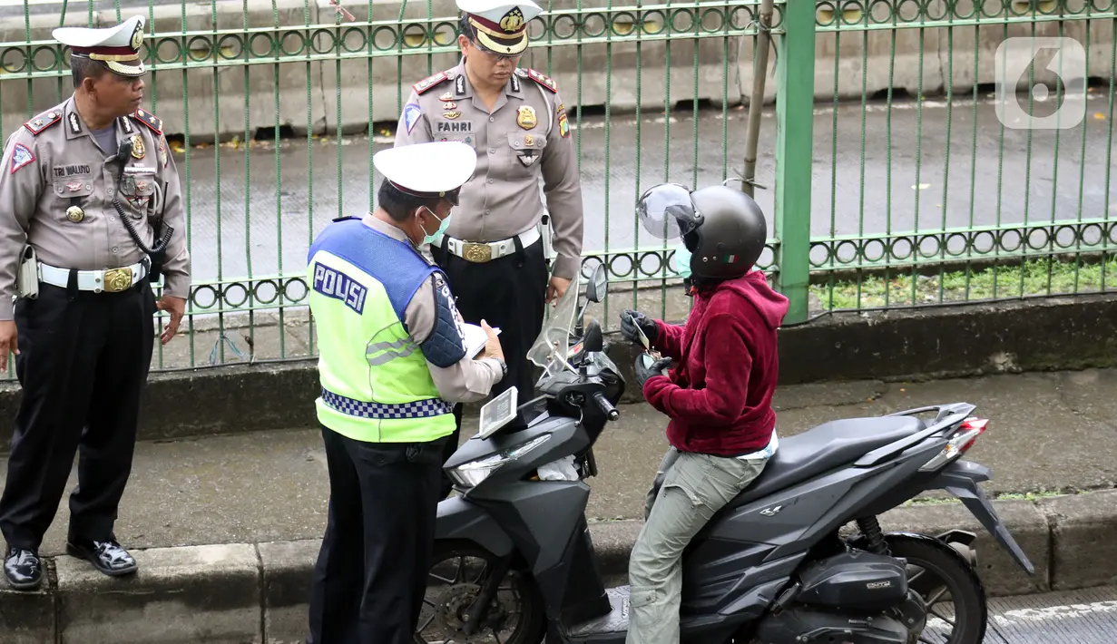 Petugas kepolisian lalu lintas merazia pengendara sepeda motor yang melintasi jalur bus Transjakarta di Jalan Sultan Agung, Manggarai, Jakarta, Kamis (6/2/2020). Meski melanggar, sebagian pengguna jalan secara sengaja masuk dan menggunakan jalur khusus bus tersebut. (Liputan6.com/Helmi Fithriansyah)