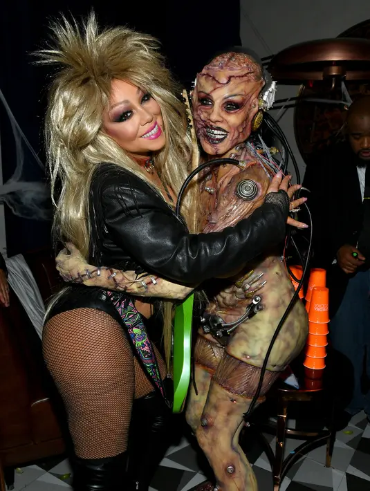 Model Heidi Klum berpose bersama penyanyi Mariah Carey saat menghadiri pesta Halloween di Cathedrale, New York (31/11/2019). Wanita 46 tahun ini memberikan aura horror pada kostumnya. (AFP Photo/Mike Coppola)