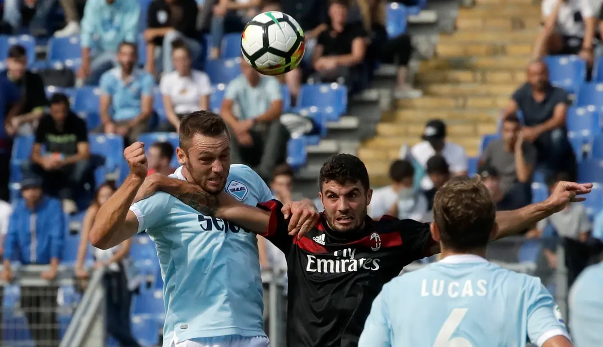 Penyerang AC Milan, Patrick Cutrone berebut bola udara dengan bek Lazio, Stefan de Vrij saat bertanding pada lanjutan Liga Serie A Italia di stadion Olimpiade Roma, (10/9). Lazio menang atas AC Milan 4-1. (AP Photo/Alessandra Tarantino)