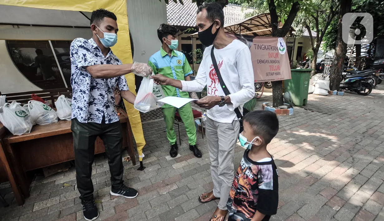 Warga menerima sembako usai mengikuti vaksinasi COVID-19 di Kantor Kelurahan Ancol, Jakarta, Kamis (17/6/2021). LMK Kelurahan Ancol membagikan sembako secara gratis kepada peserta vaksinasi COVID-19. (merdeka.com/Iqbal S. Nugroho)