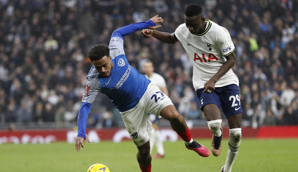 Gelandang Tottenham Hotspur, Pape Matar Sarr (kanan) berebut bola dengan gelandang Portsomuth, Josh Koroma pada laga putaran ketiga Piala FA 2022/2023 di Tottenham Hotspur Stadium, London (7/1/2023). Pape Matar Sarr didatangkan Tottenham Hotspur dari FC Metz pada awal musim 2021/2022, namun langsung dipinjamkan ke FC Metz selama semusim. Setelah kembali dari masa peminjaman sejak awal musim 2022/2023, ia masih tetap kekurangan jatah bermain dan hanya tampil 14 laga di semua ajang hinga kini. (AFP/Ian Kington)