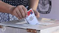 Warga memasukkan surat suara ke dalam kotak suara saat menggunakan hak pilih pada pemungutan suara Pilkada Depok di TPS Kampung Pilkada RW 03, Depok, Jawa Barat, Rabu (9/12). (Liputan6.com/Immanuel Antonius)